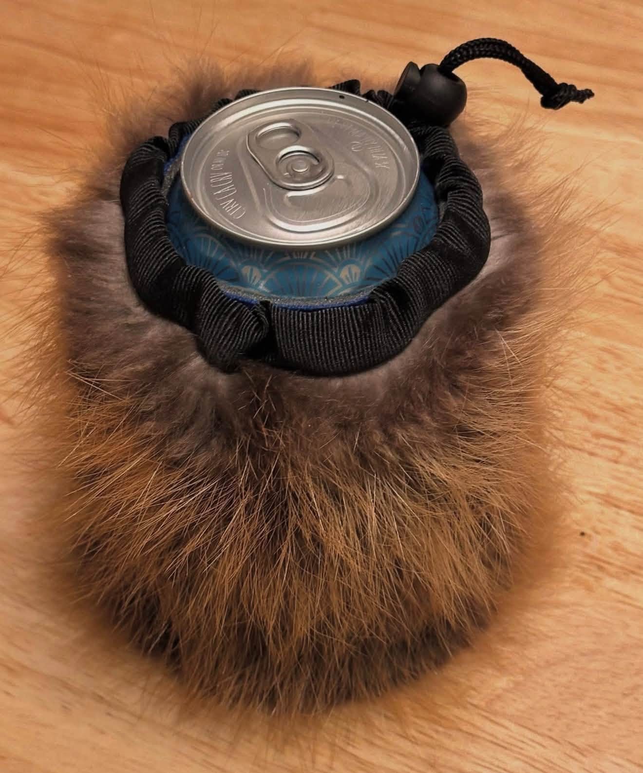 Coyote fur can cooler closed around a drink can